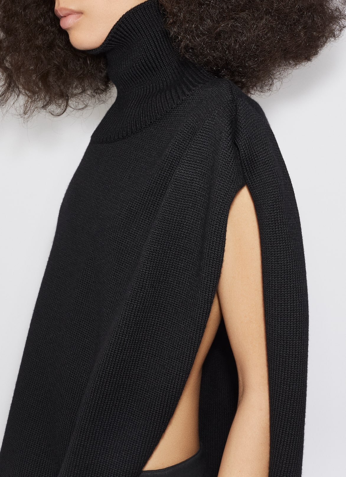 KNITTED ASYMMETRICAL CAPE JUMPER ALAÏA BLACK KNITTED ASYMMETRICAL CAPE JUMPER